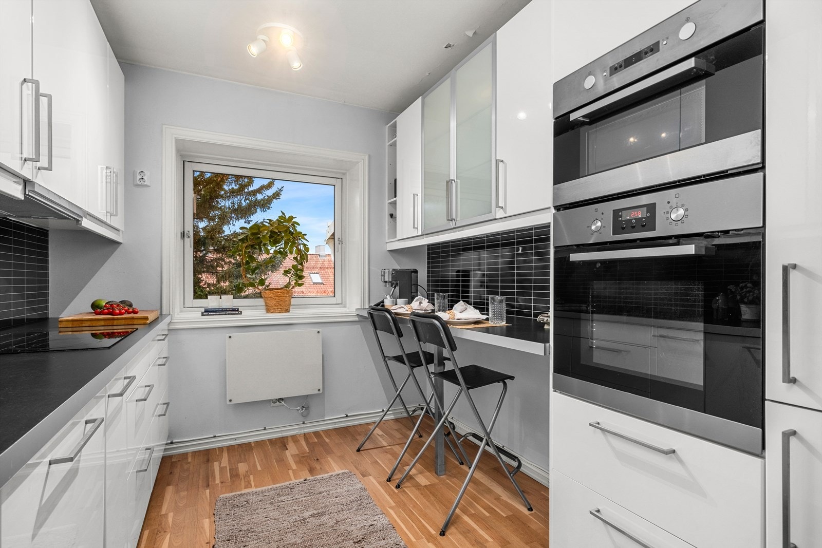 Kjøkkenet byr på praktiske sittemuligheter ved kjøkkenbenken for barstoler Galleribilde