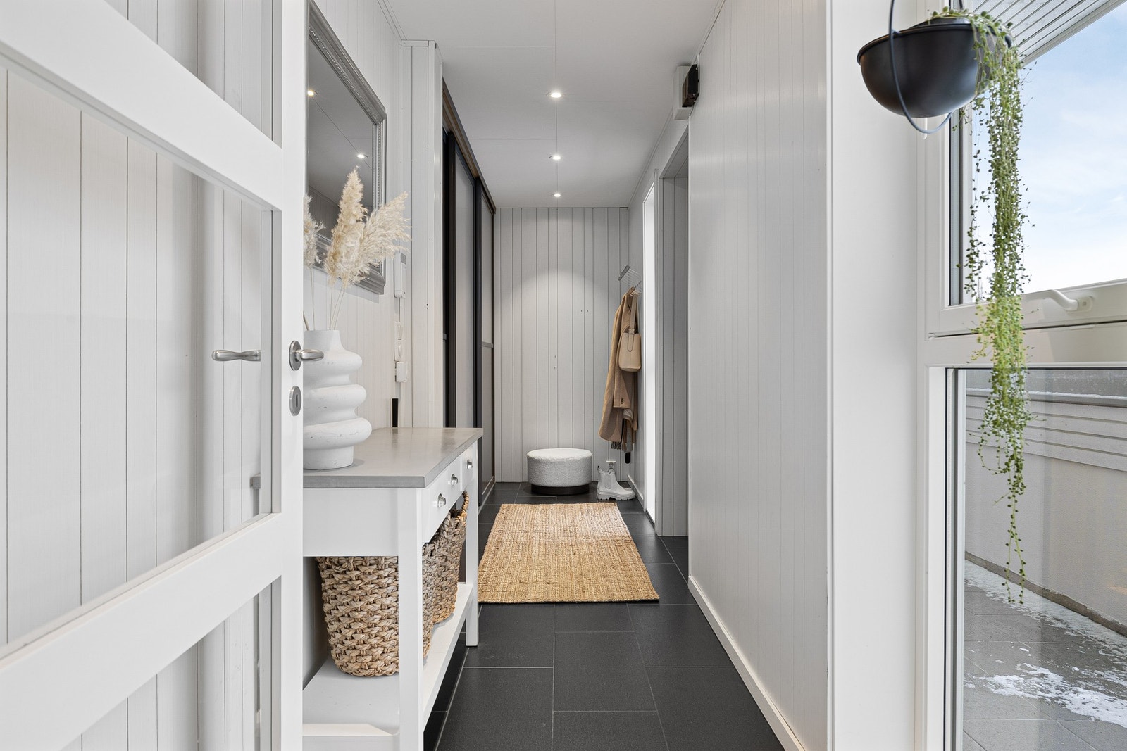 1. etasje - entré.
Innbydende entré med behagelig, vannbåren varme og god oppbevaringsplass for sko og yttertøy i skyvedørsgarderobe. Galleribilde