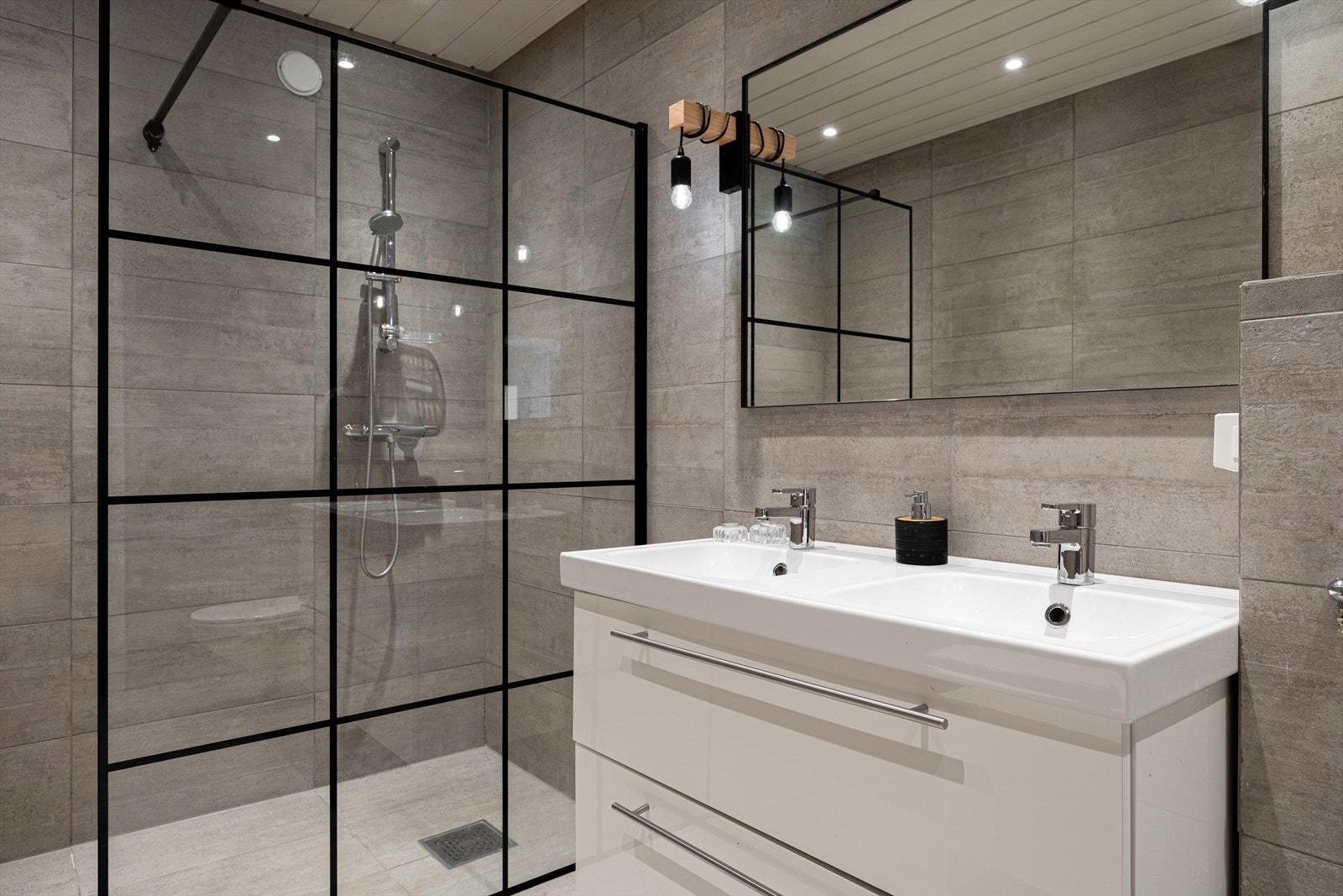 Innredning bestående av bl.a. servantskap med glatte, høyglansfronter og heldekkende servant, veggmontert klosett og dusjhjørne med glassvegg Galleribilde