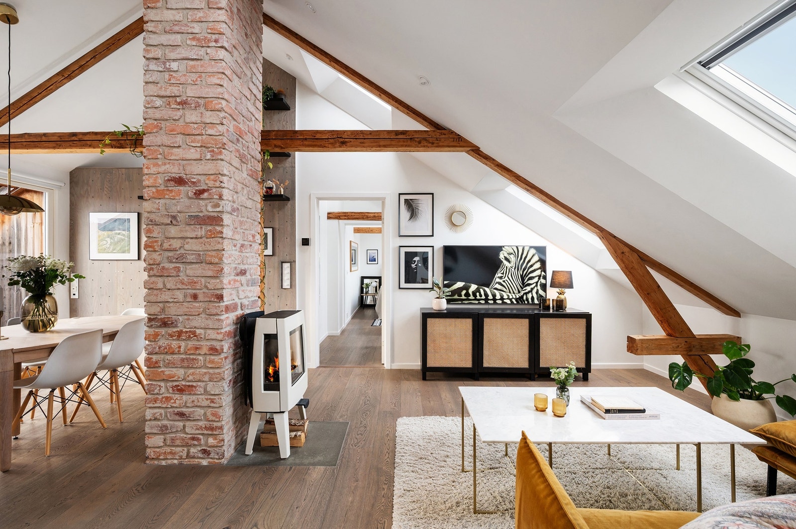 Stuen har en god atmosfære med lekre detaljer som sjarmerende takbjelker og en sentralt plassert mursteinspipe. Galleribilde