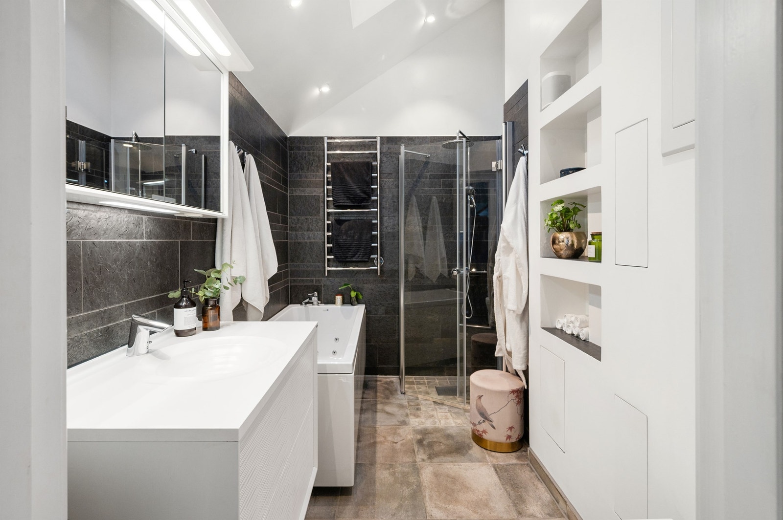 Lekkert flislagt bad med eksklusiv norsk naturstein som skiferstriper i Otta Pillarguri og store fliser i Oppdal-skifer. Varme i gulvet sørger for en behagelig start på dagen. Galleribilde