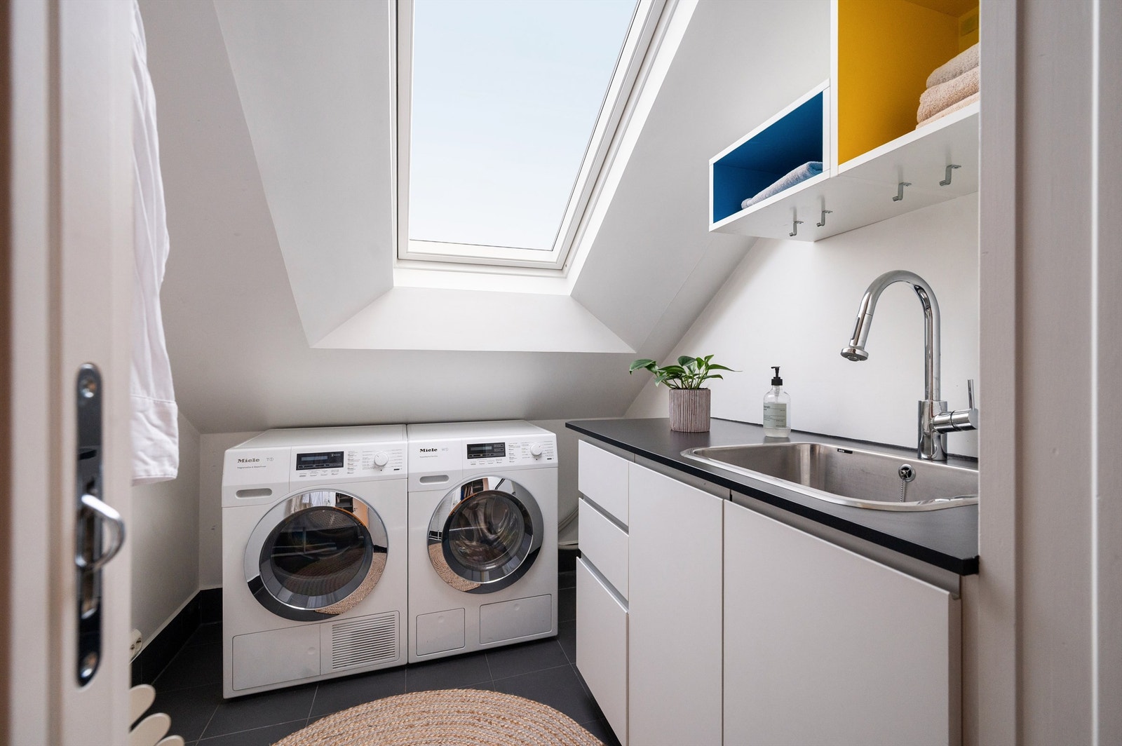 Separat vaskerom med flislagt gulv, gulvvarme og opplegg for vaskemaskin. Galleribilde