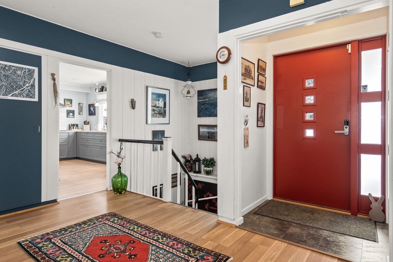 Åpen og romslig gang med trapp som fører til underetasjen. Galleribilde