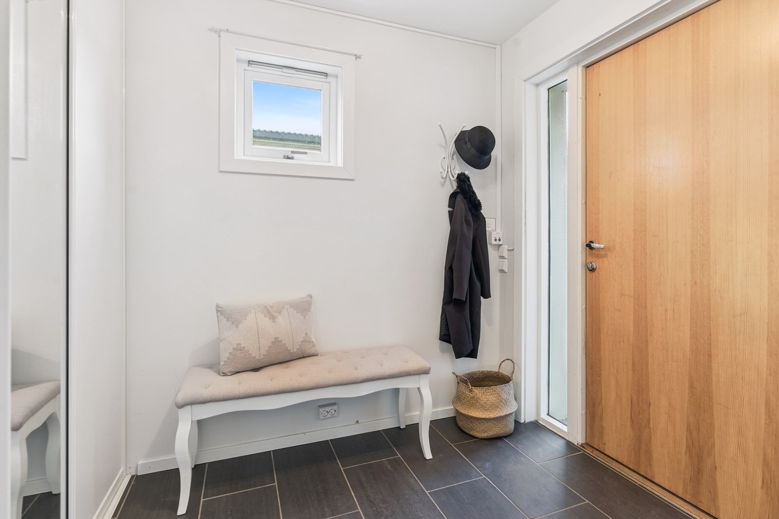 Her kjem du inn i ein romsleg gang med flis på golv med varmekablar. Du har praktisk oppbevaring med skyvedørsgarderobe i entrèen. Galleribilde