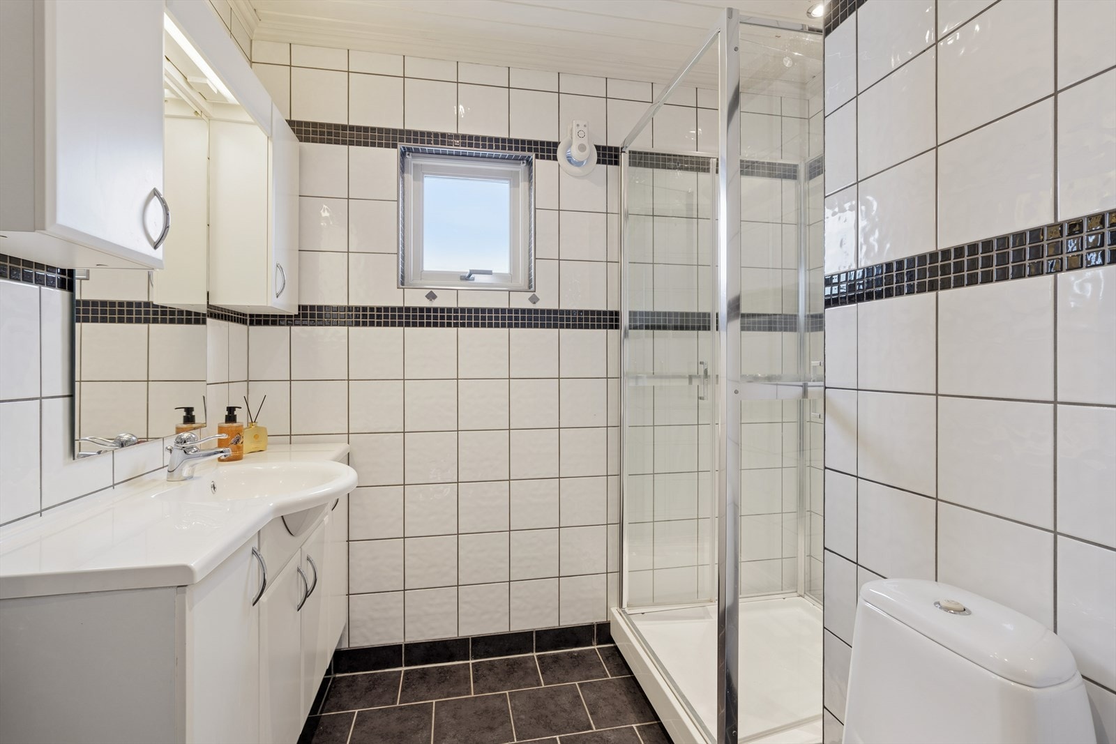 Rommet har dusjkabinett (2022), WC, baderomsinnredning med servant og speil. Galleribilde