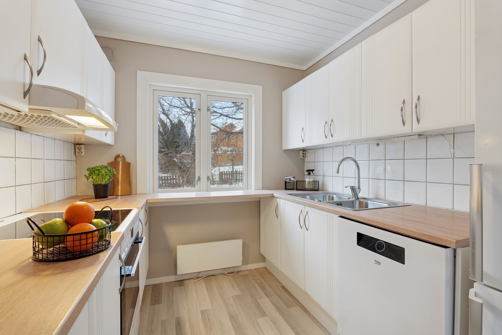 Benkeplaten er i laminat, og det er nedfelt benkebeslag med to kummer. Over deler av benken er det fliser. Galleribilde