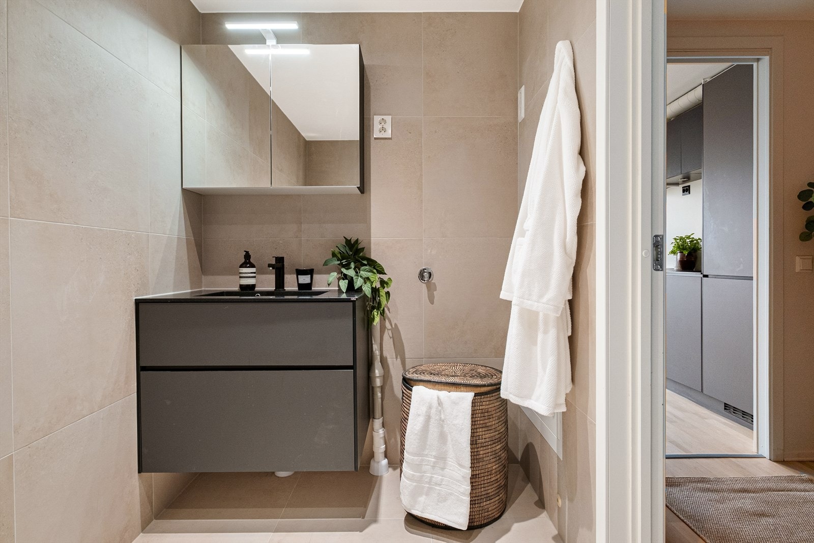 Nydelig bad fra 2026 med lekre fliser i naturtoner, gulvvarme og mekanisk avtrekk. Galleribilde