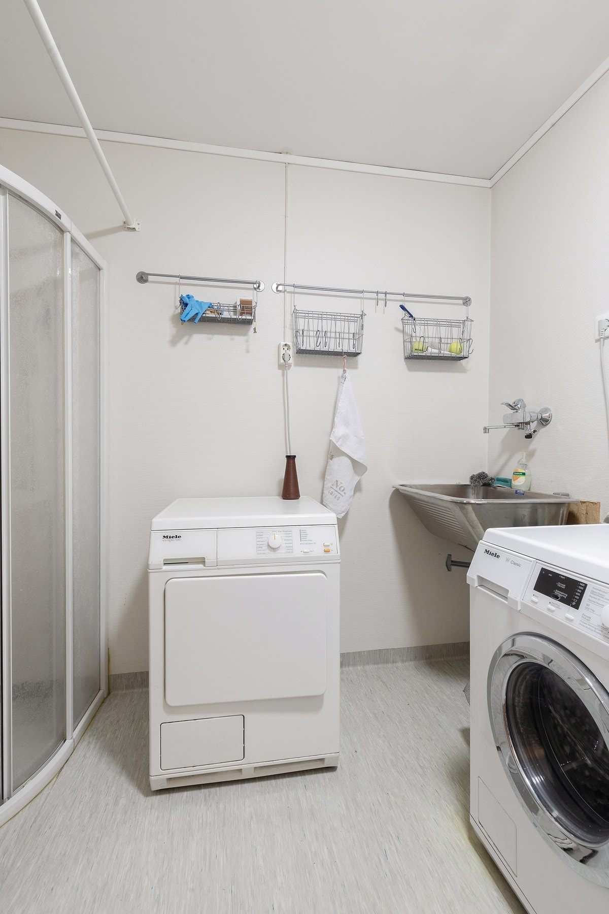 I leilighetens andre etasje finner du et stort vaskerom med vinylbelegg på gulv og tapet på vegger og mekanisk avtrekk. Rommet er innredet med utslagsvask, dusj og opplegg for vaskemaskin. Galleribilde