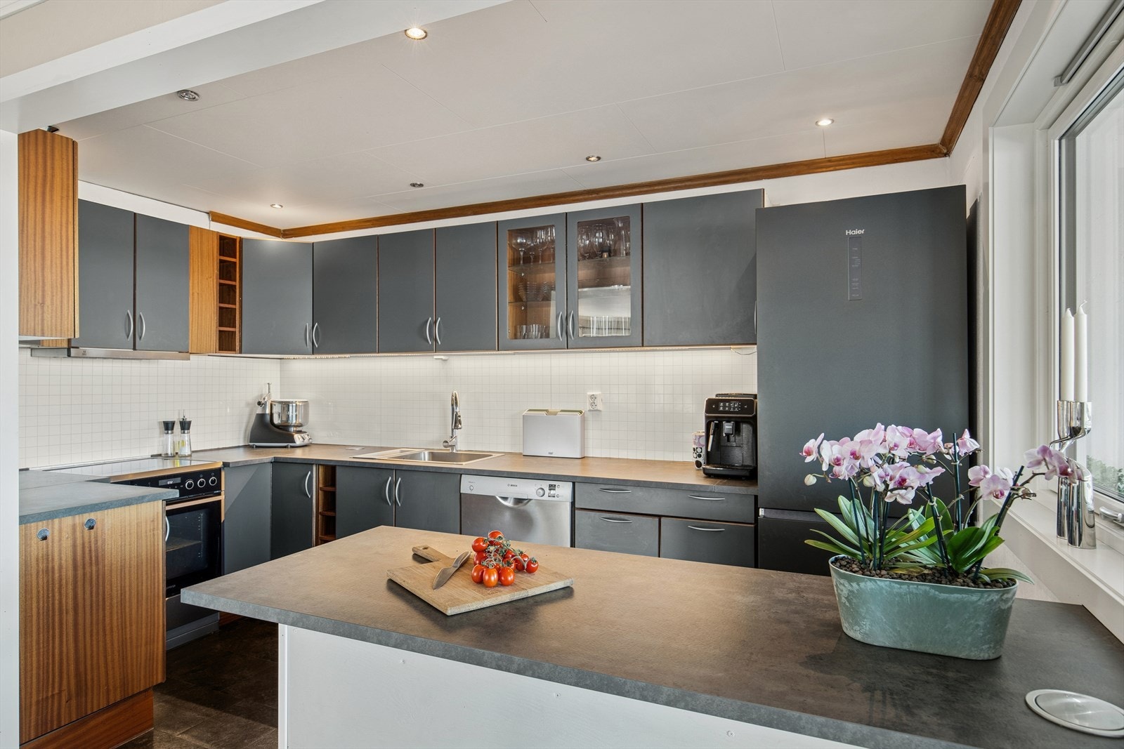 Kjøkkeninnredningen har slette fronter med en benkeplate i laminat, og det er montert plater mellom benken og overskapene. Galleribilde