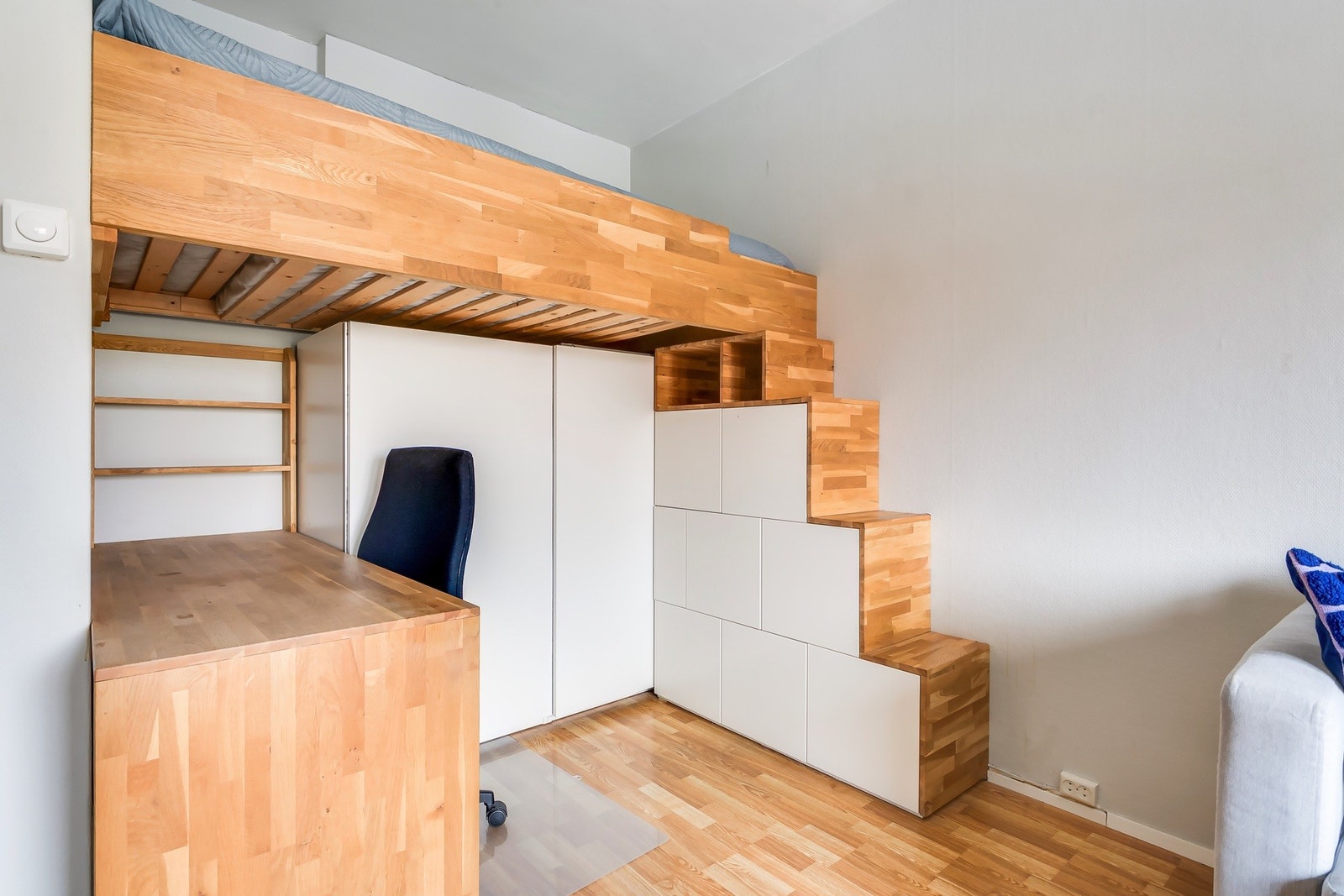 Hemsesengen er bygget over en kombinasjon av skap og arbeidsplass, noe som utnytter plassen effektivt Galleribilde