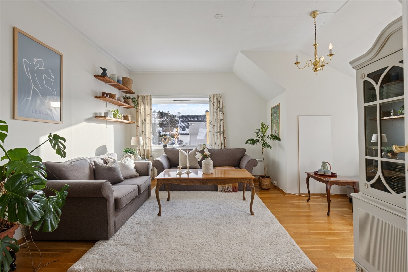 Lys stue i andre etasje med parkett på gulv og malte flater. Galleribilde