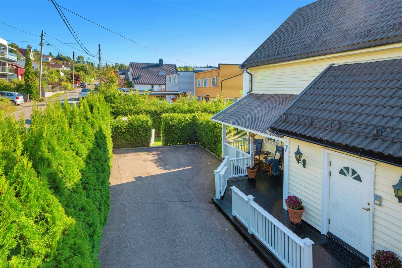 Stor, asfaltert gårdsplass med parkering for to biler. Galleribilde