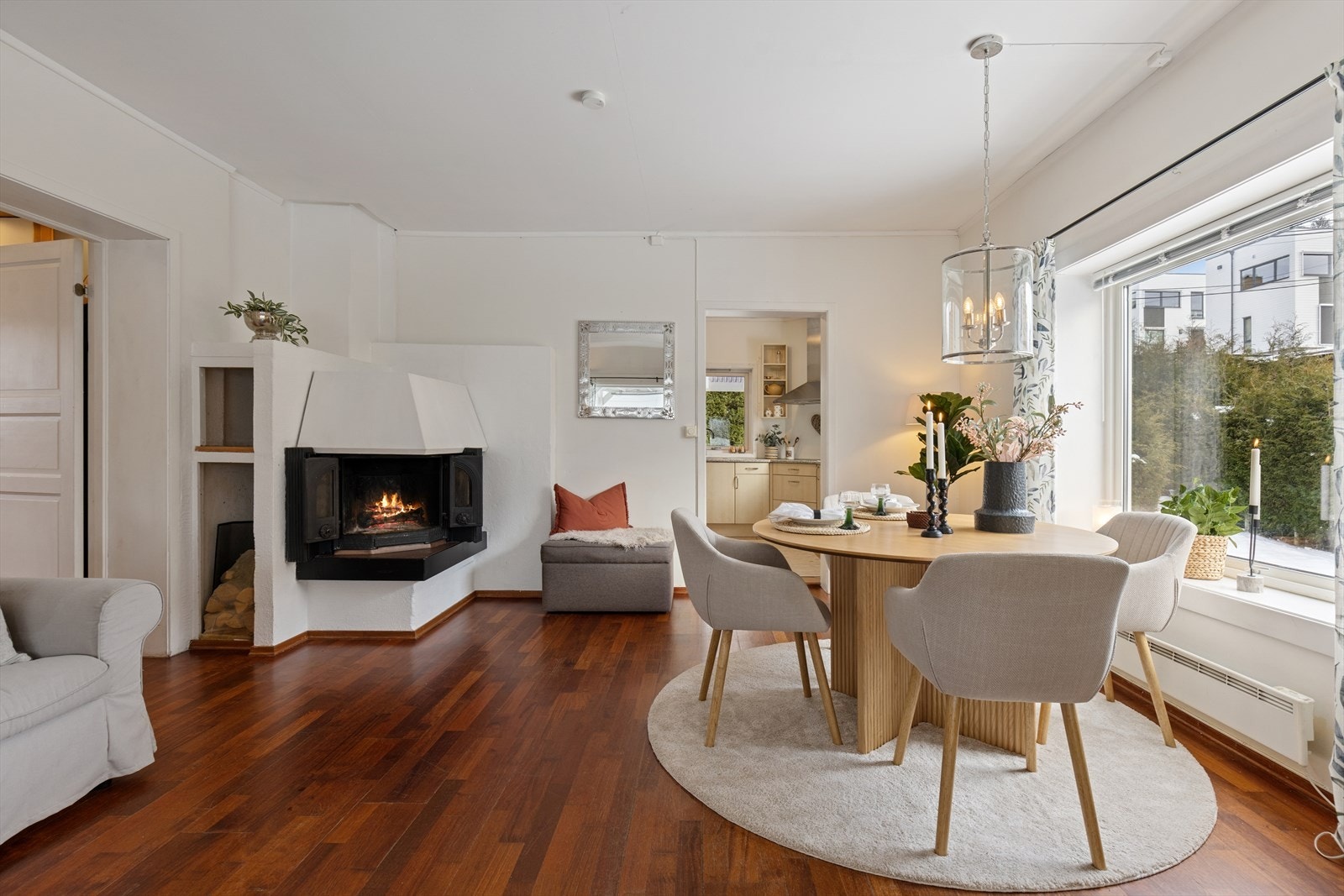 Stuen i første etasje er et sosialt rom med åpen peis og plass til spisebord. Galleribilde