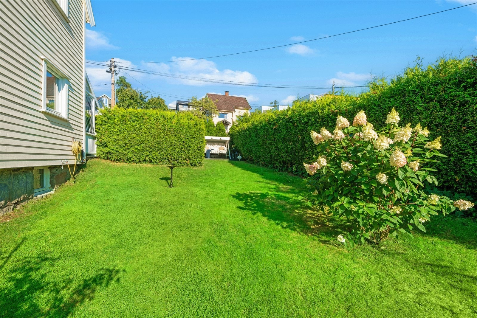 Tomten er pent opparbeidet med plen og beplantning som rammer inn eiendommen. Galleribilde