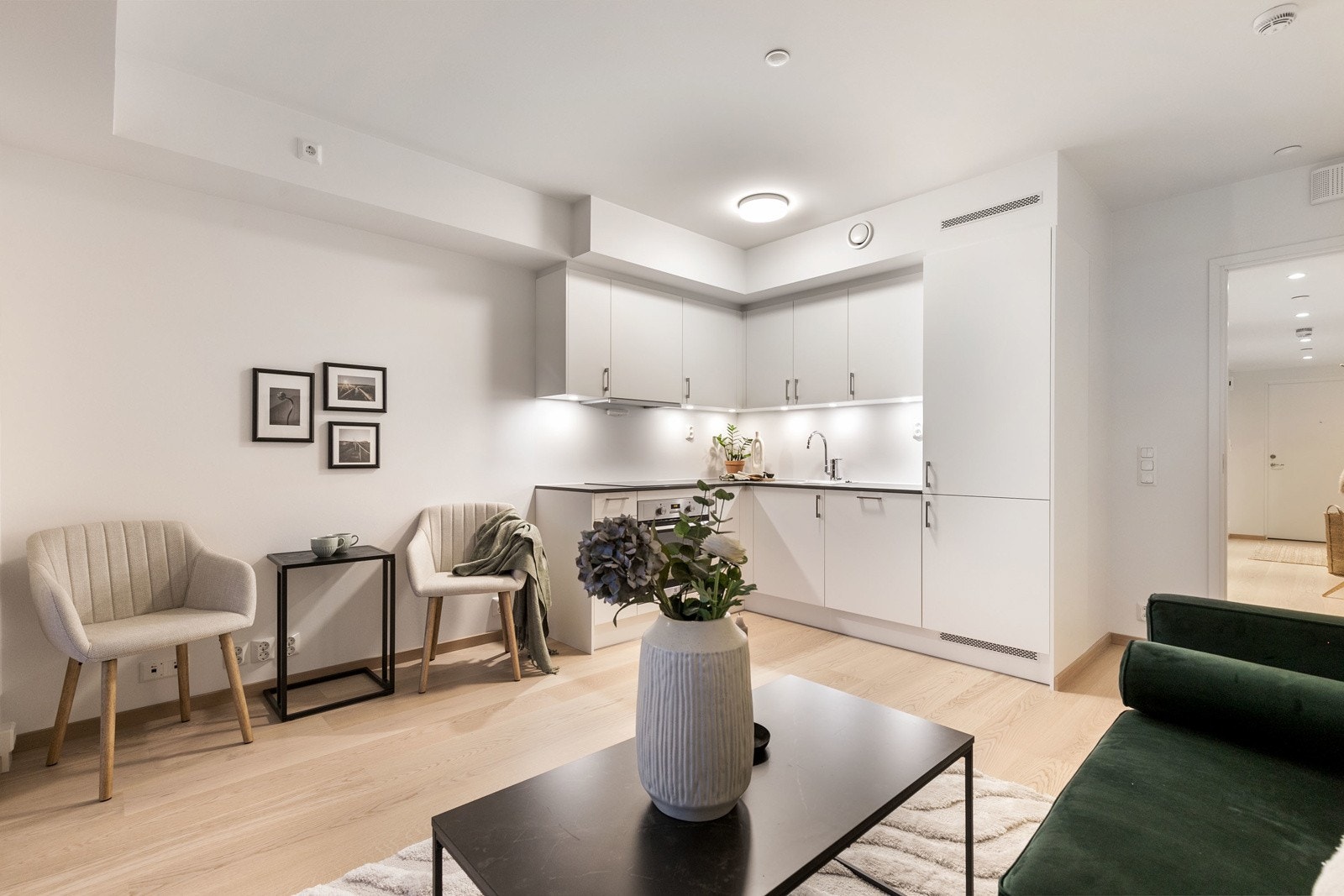 Lekkert kjøkken i åpen løsning mot stue, med integrerte hvitevarer. Bilde fra L207 Galleribilde