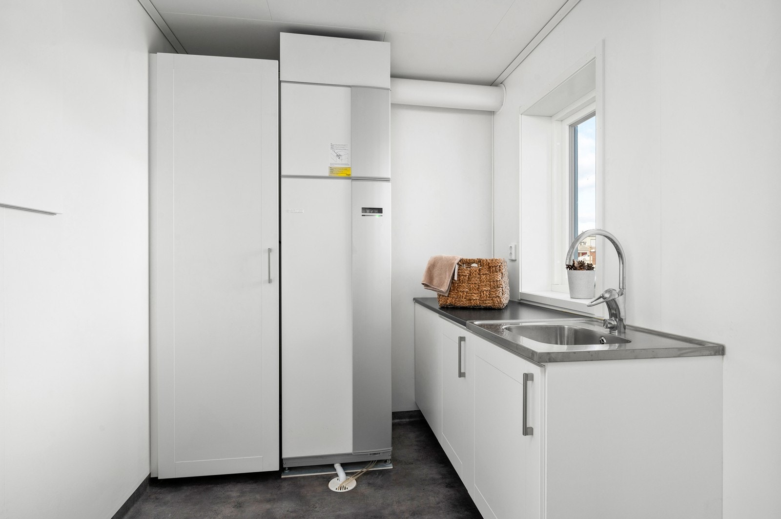 Vaskerommet er av god størrelse, har skapinnredning med lagringsplass, nedfelt utslagsvask, og opplegg for vaskemaskin og tørketrommel. Galleribilde