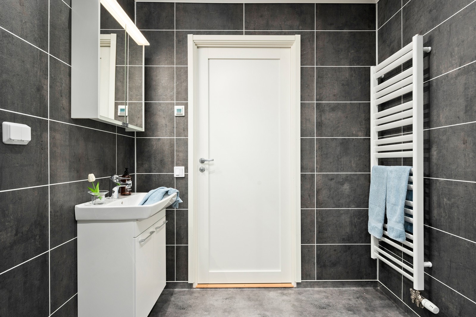 Begge badene har håndkletørker med vannbåren varme Galleribilde