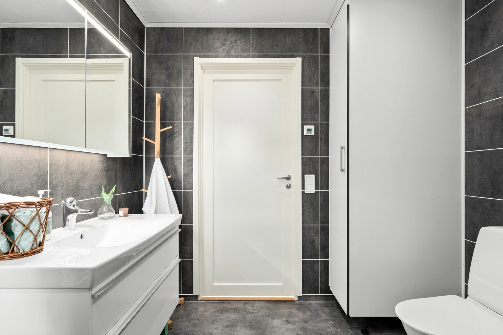 Rommet er innredet med heldekkende servant i innredning med skuffer, med speilskap over servanten Galleribilde