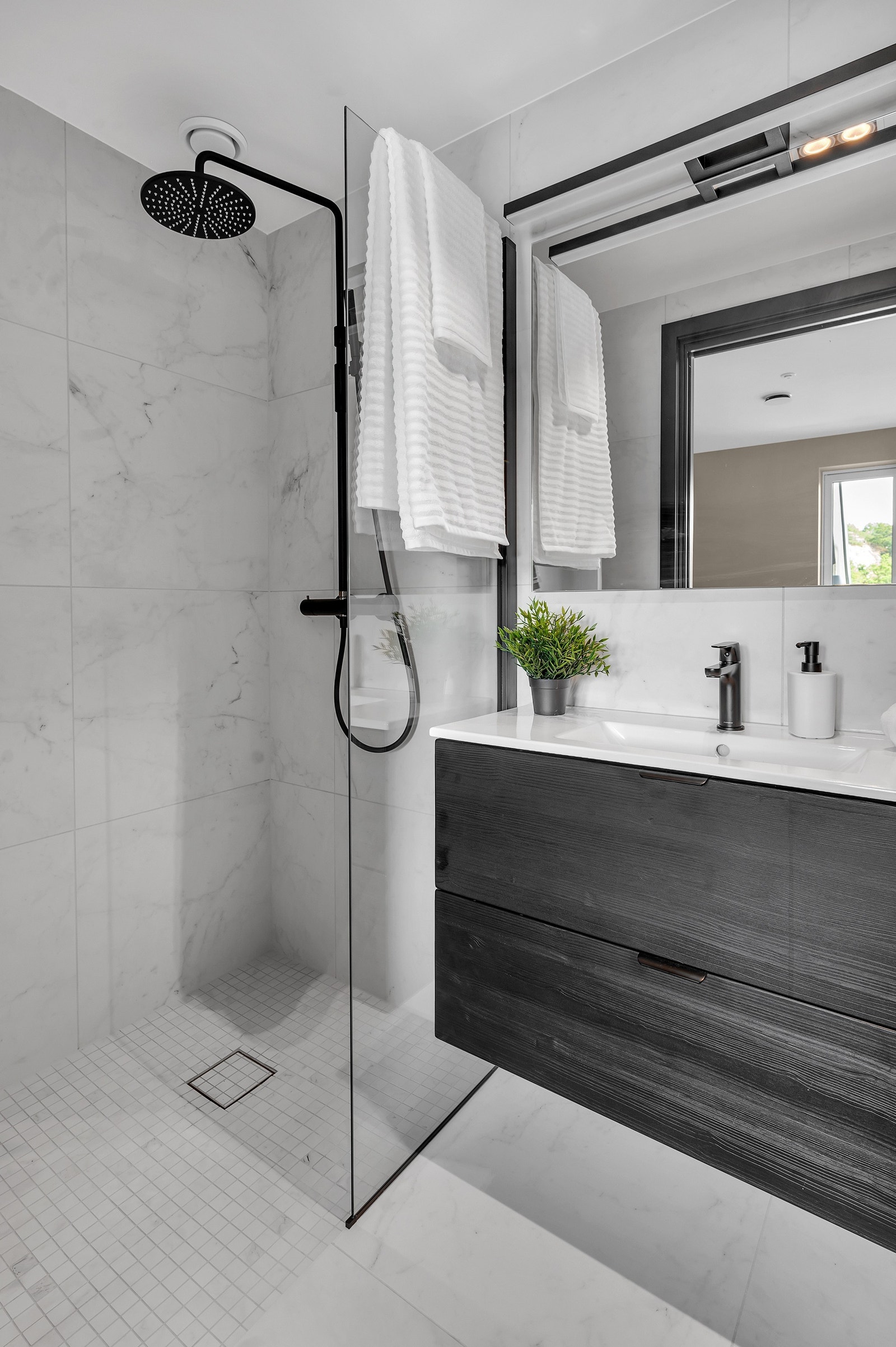 Badet har sorte og hvite detaljer samt spotter i taket. Galleribilde