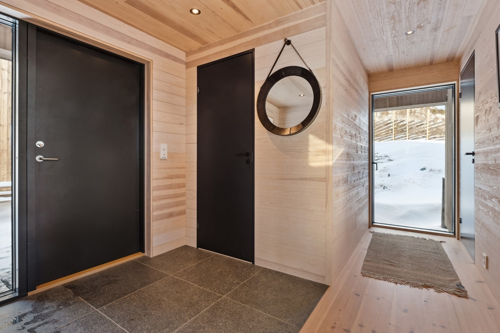 Man ønskes velkommen av en entré med store gulvfliser, og både entreen og den tilliggende gangen har varme i gulvet. Galleribilde