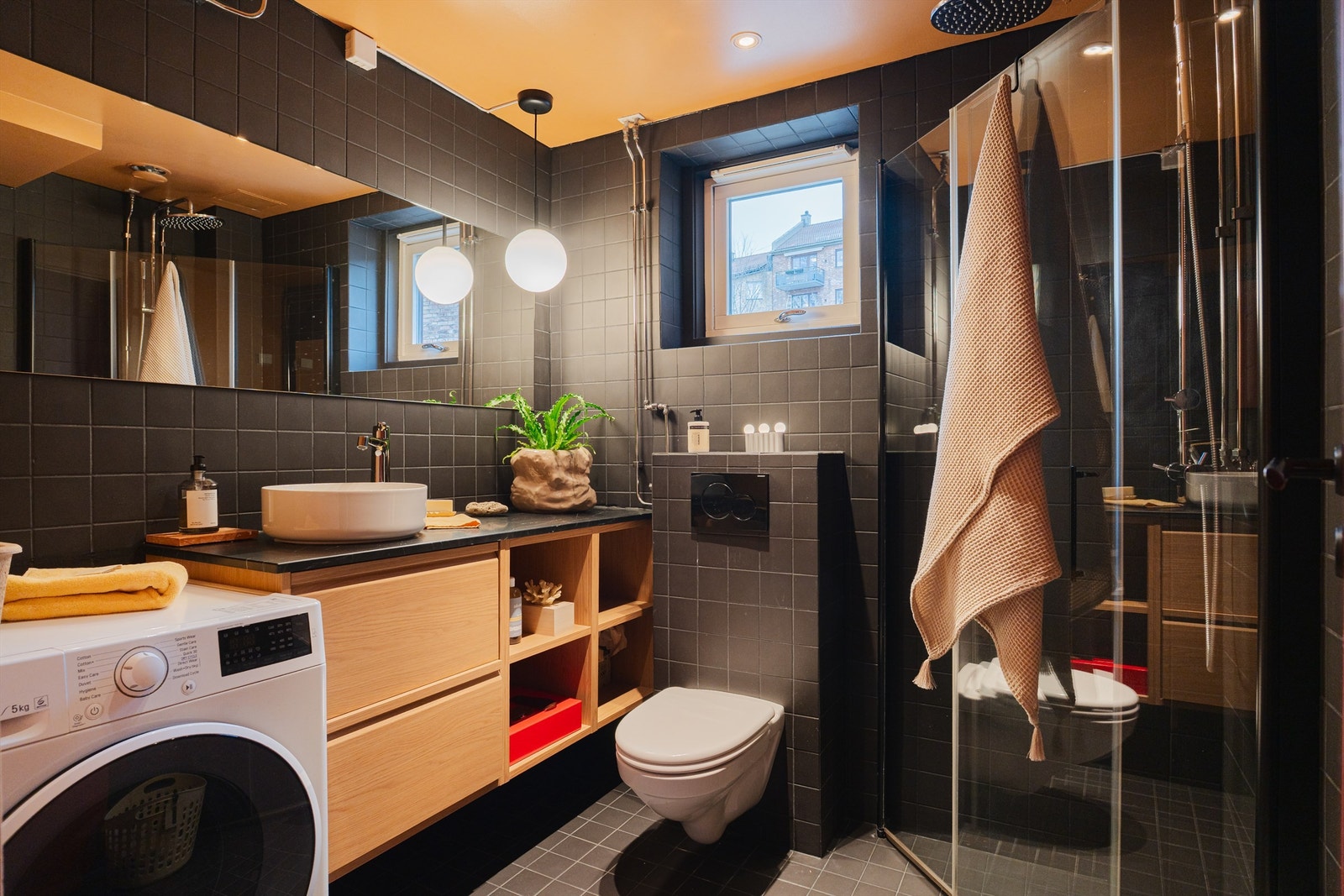 Pent, flislagt bad med varme i gulvet og opplegg for vaskemaskin. Dusjhjørne med svingbare glassdører og et vegghengt klosett for enkelt renhold. Galleribilde