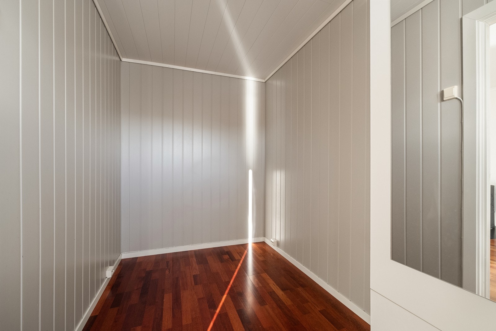 Sovealkoven har panelte vegger og parkett på gulv. Galleribilde