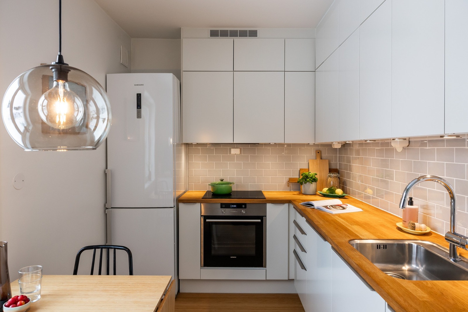 Moderne HTH kjøkken med hvite, glatte fronter kombinert med benkeplate i eik (oljet februar 2026). Galleribilde