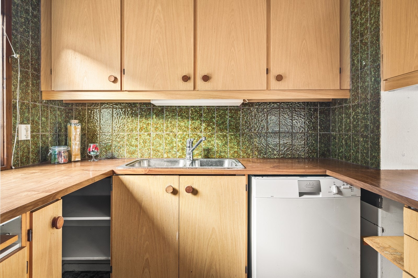 Mellom benkeplate og overskap er det fliser som gir en dekorativ effekt. Galleribilde