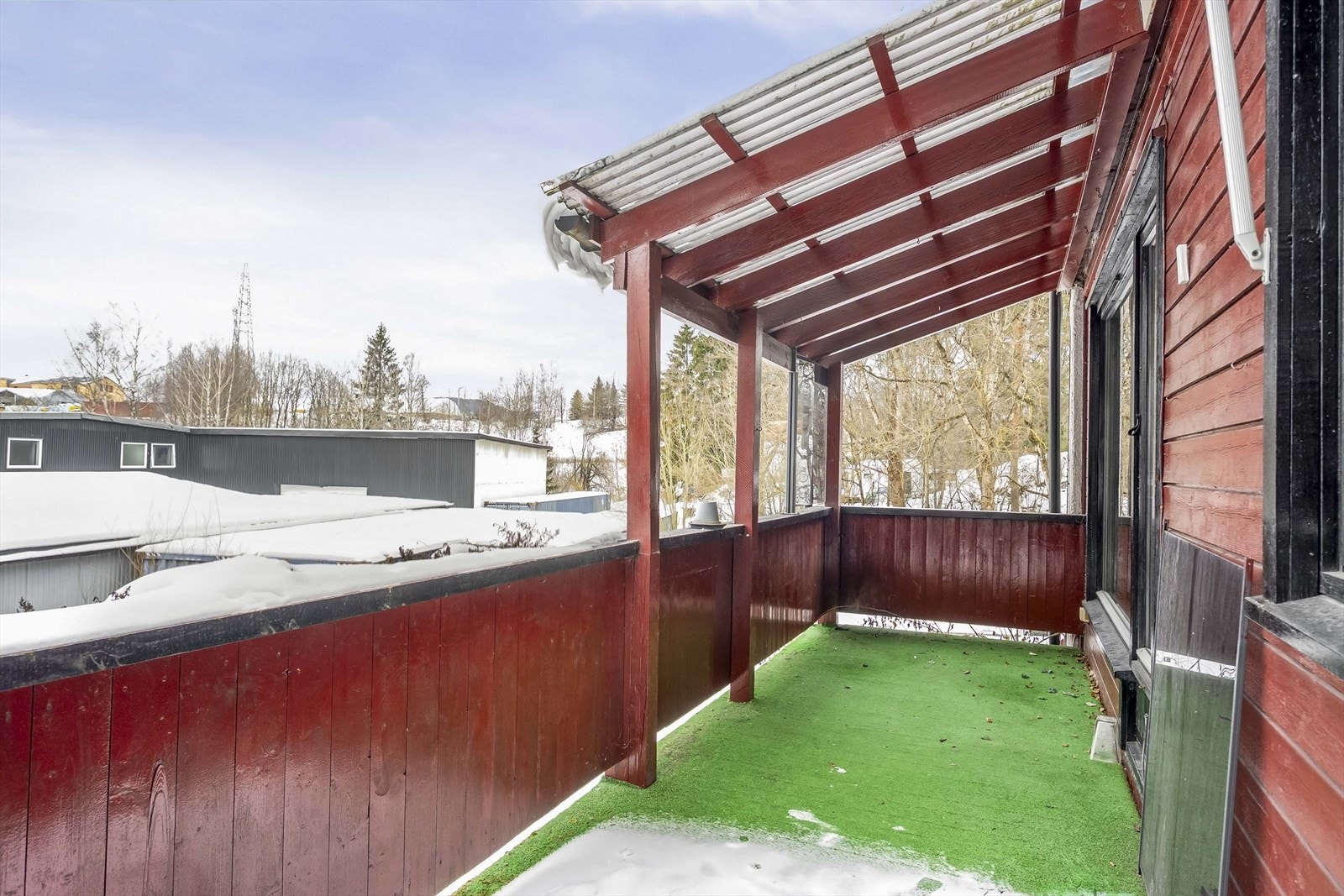 Balkongen er bygget i treverk og har et tak som gir ly for vær og vind. Galleribilde