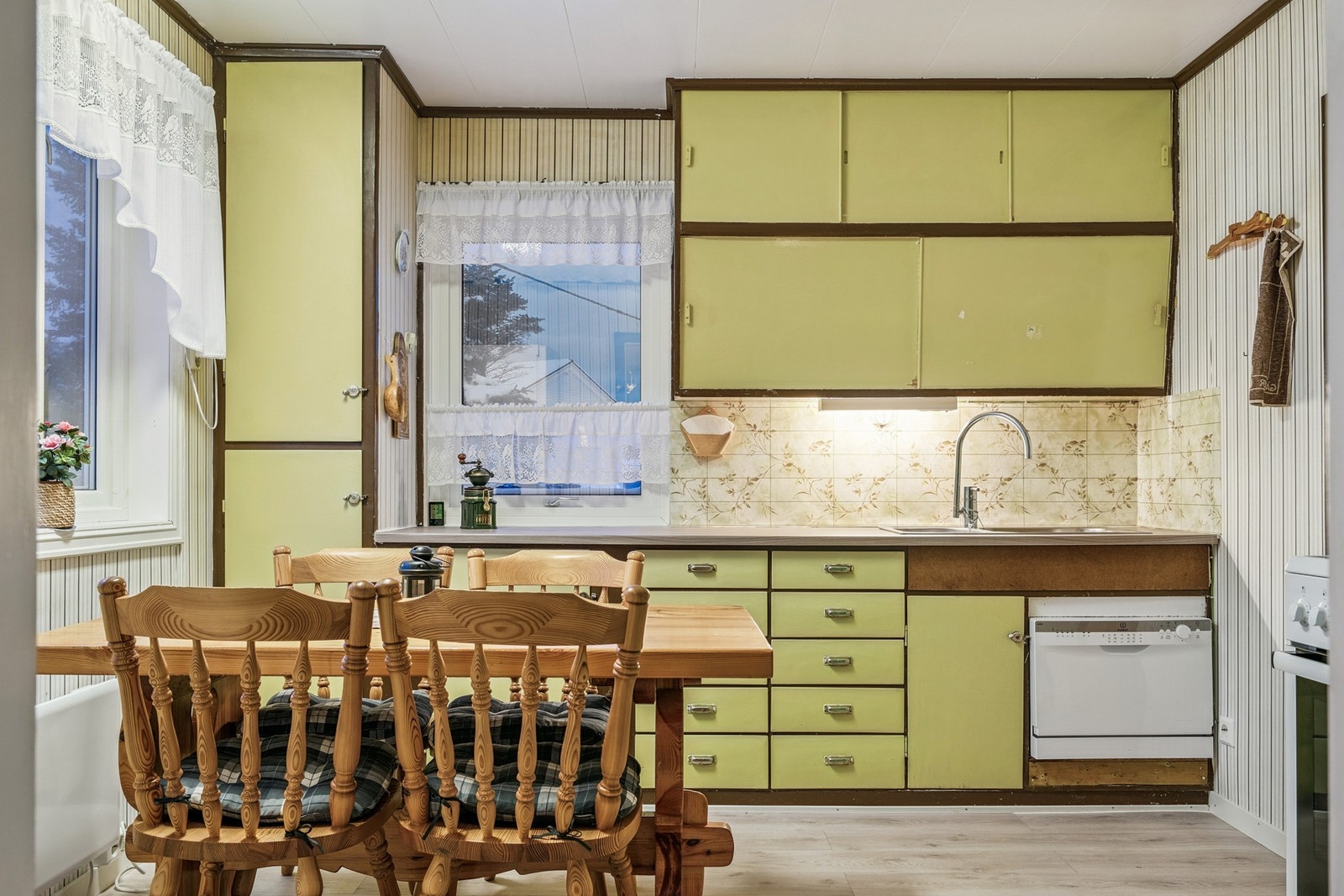 Eldre kjøkkeninnredning med glatte fronter og laminat benkeplate. Galleribilde