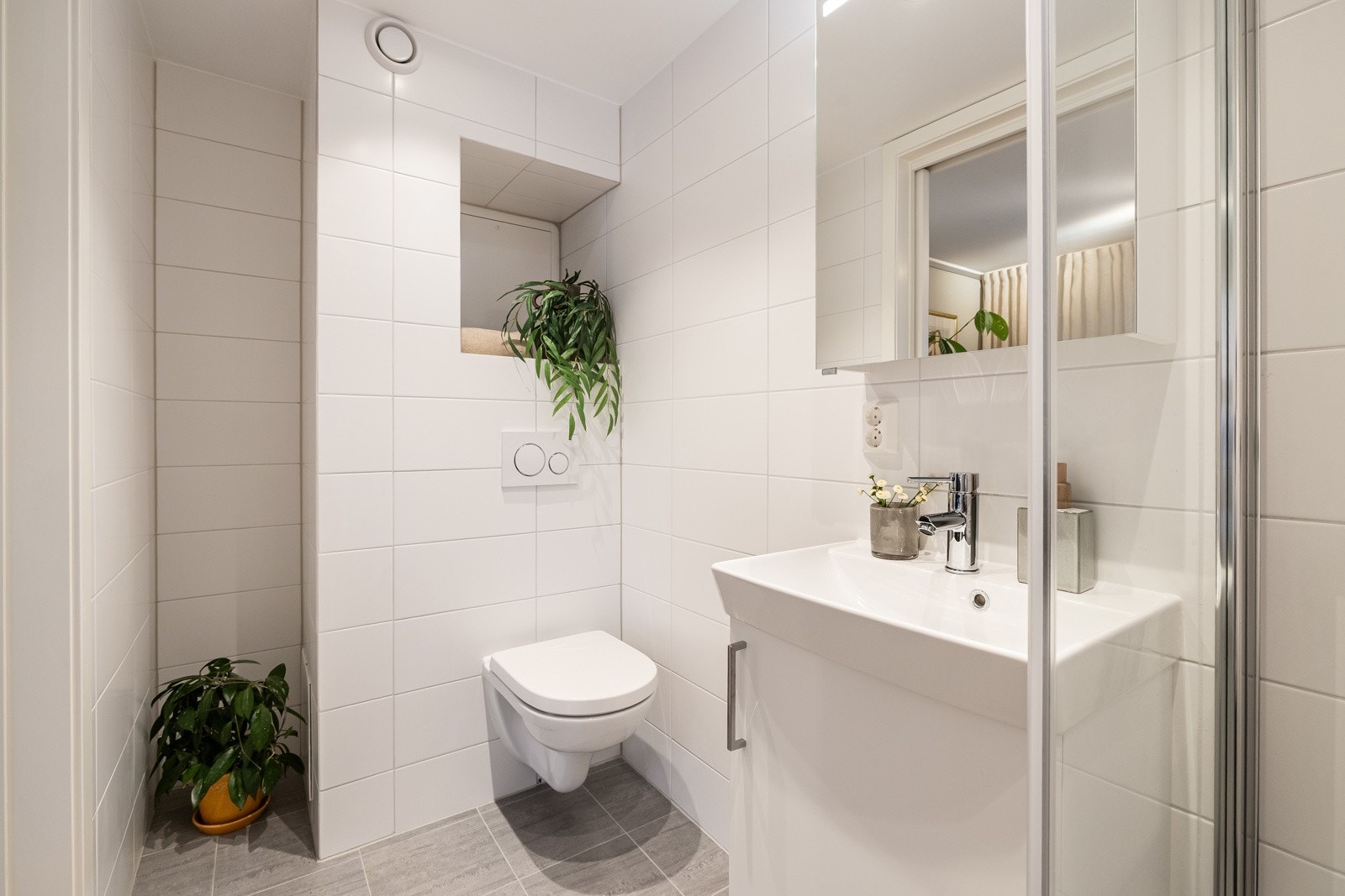 Begge badene har flislagte vegger og gulv med gulvvarme, samt downlights i himlingen, noe som gir et moderne og komfortabelt uttrykk. Galleribilde