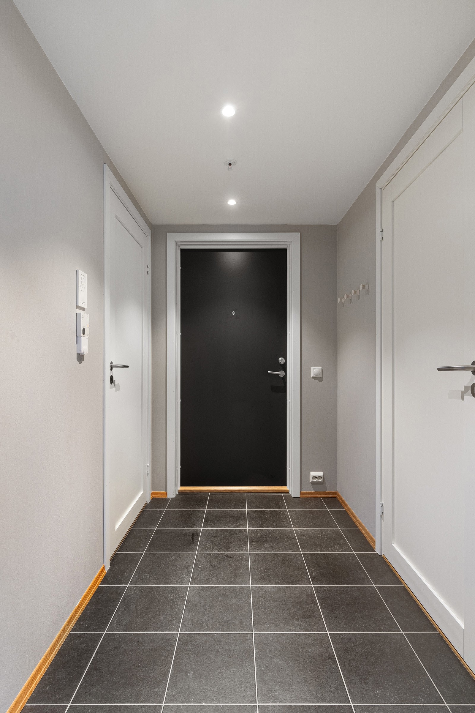 Velkommen inn. Flislagt entré med spotter i tak.