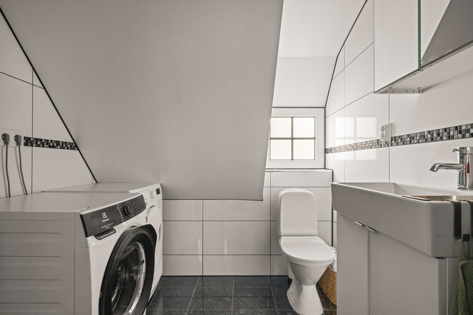 Badet er flislagt med varmekabler og har opplegg for vaskemaskin. Galleribilde