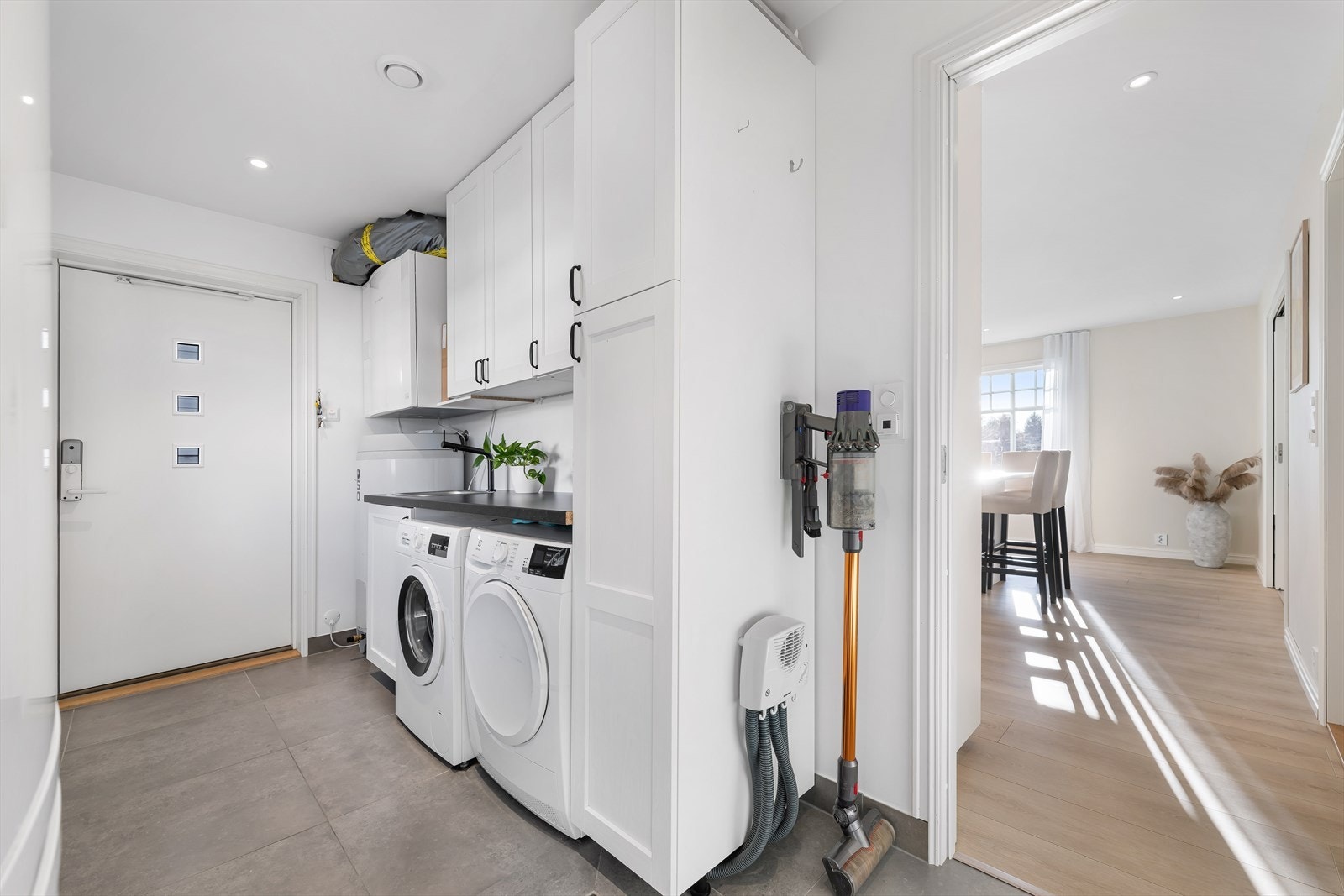 Vaskerommet er romslig og har egen inngang fra siden av huset. Her har man god plass for vask/tørk, egen brettebenk med skapinnredning, utslagsvask og god plass for yttertøy. Galleribilde