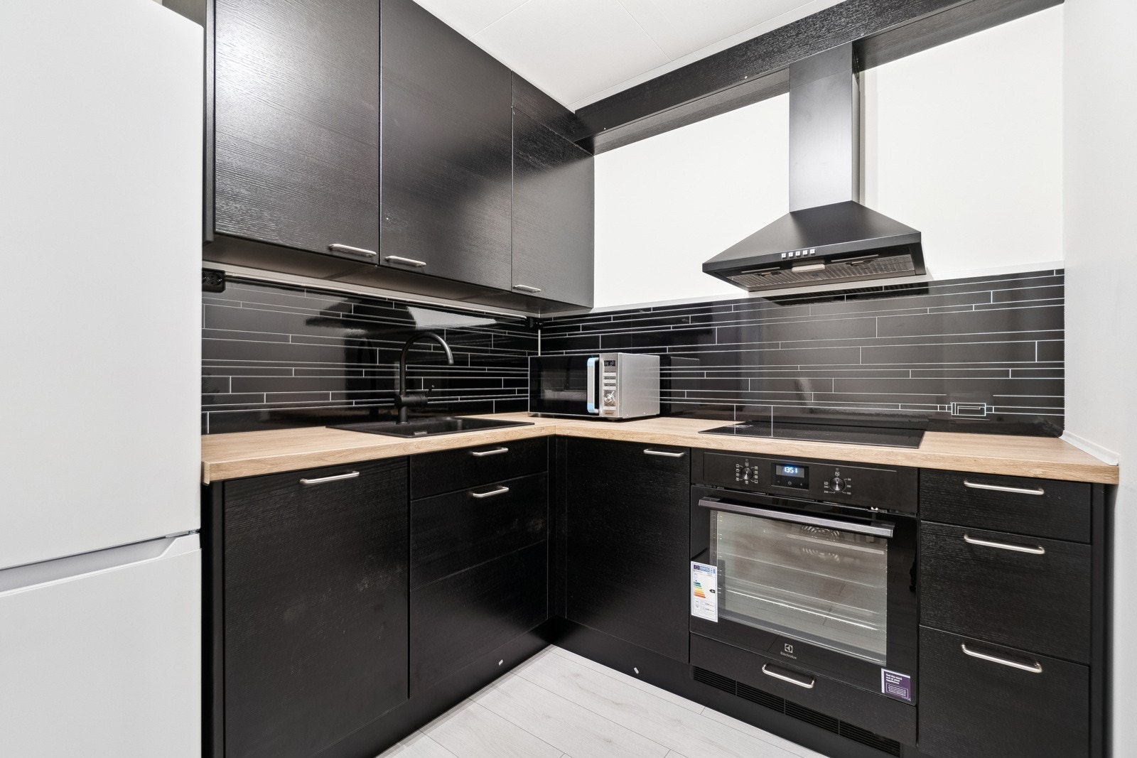 Kjøkkeninnredningen er fra 2024 og ubrukt. Innredningen fremstår innbydende med svarte fronter og benkeplate i eik. Galleribilde