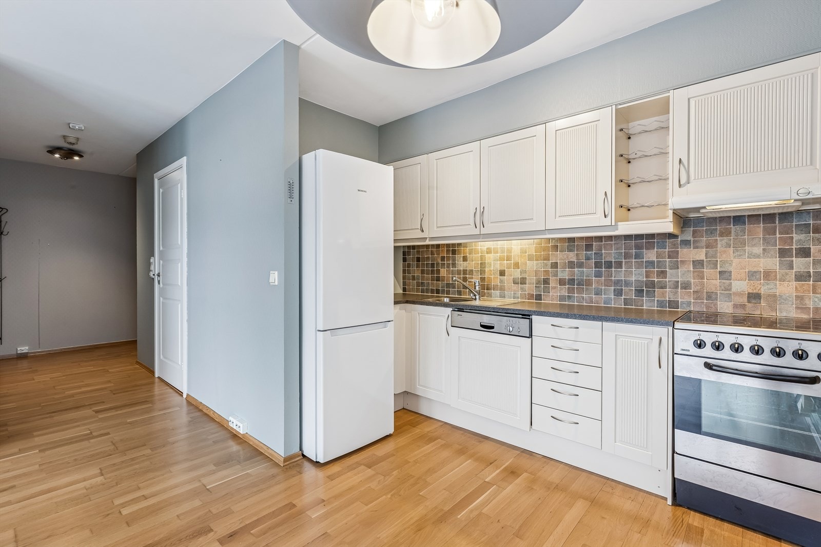 Det er flislagt mellom benk og overskap, og oppvaskmaskinen er integrert. Galleribilde