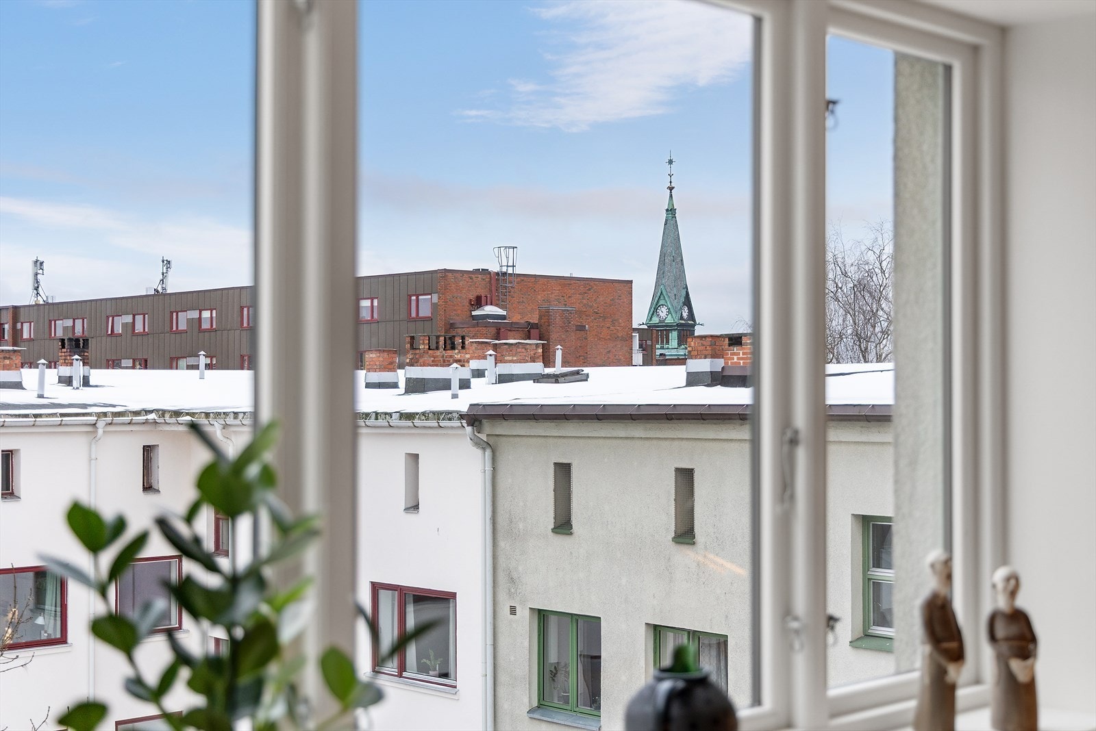 Store vinduer gir utsikt over nærliggende bygninger og kirketårn. Galleribilde