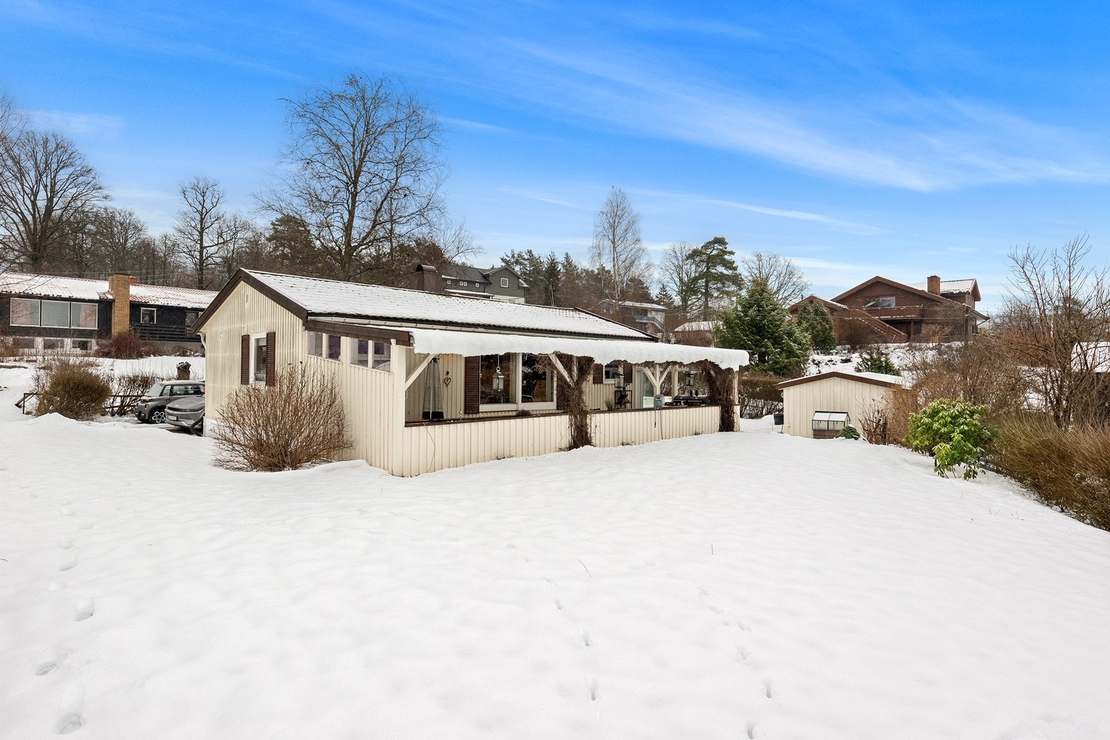 Eneboligen ligger på en 906,5 m² stor, skrånende tomt som er pent opparbeidet. Galleribilde