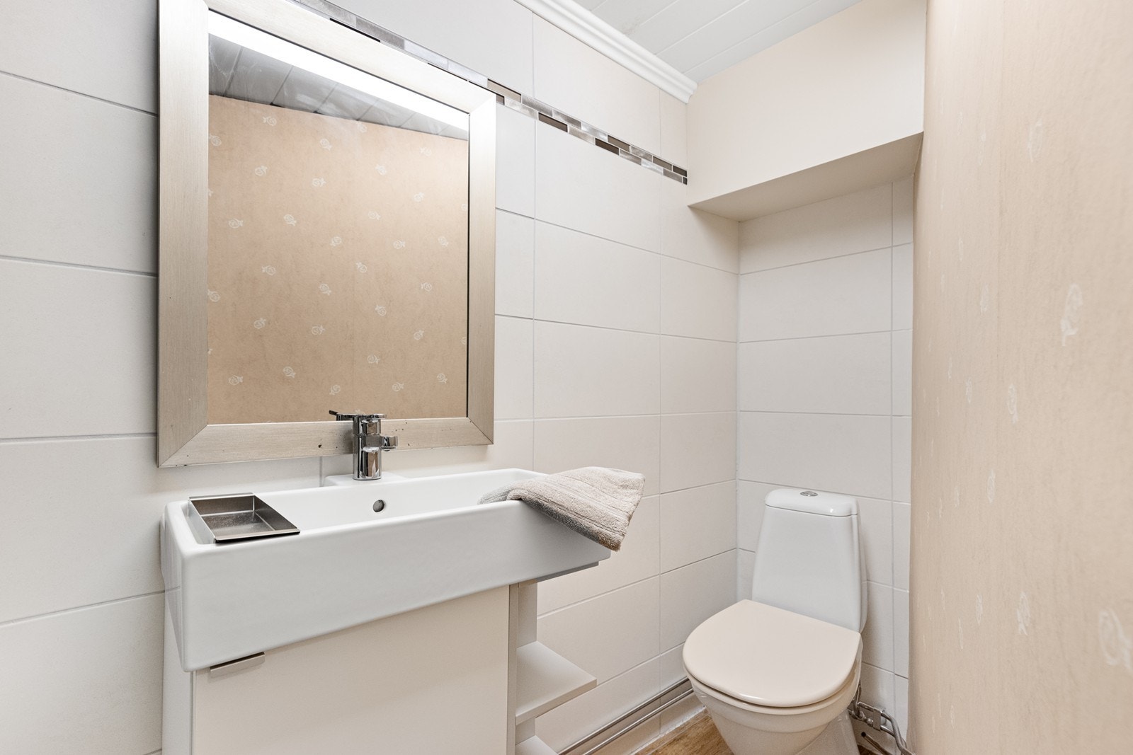 Rommet har flislagt gulv med varme, toalett og opplegg for vaskemaskin. Galleribilde