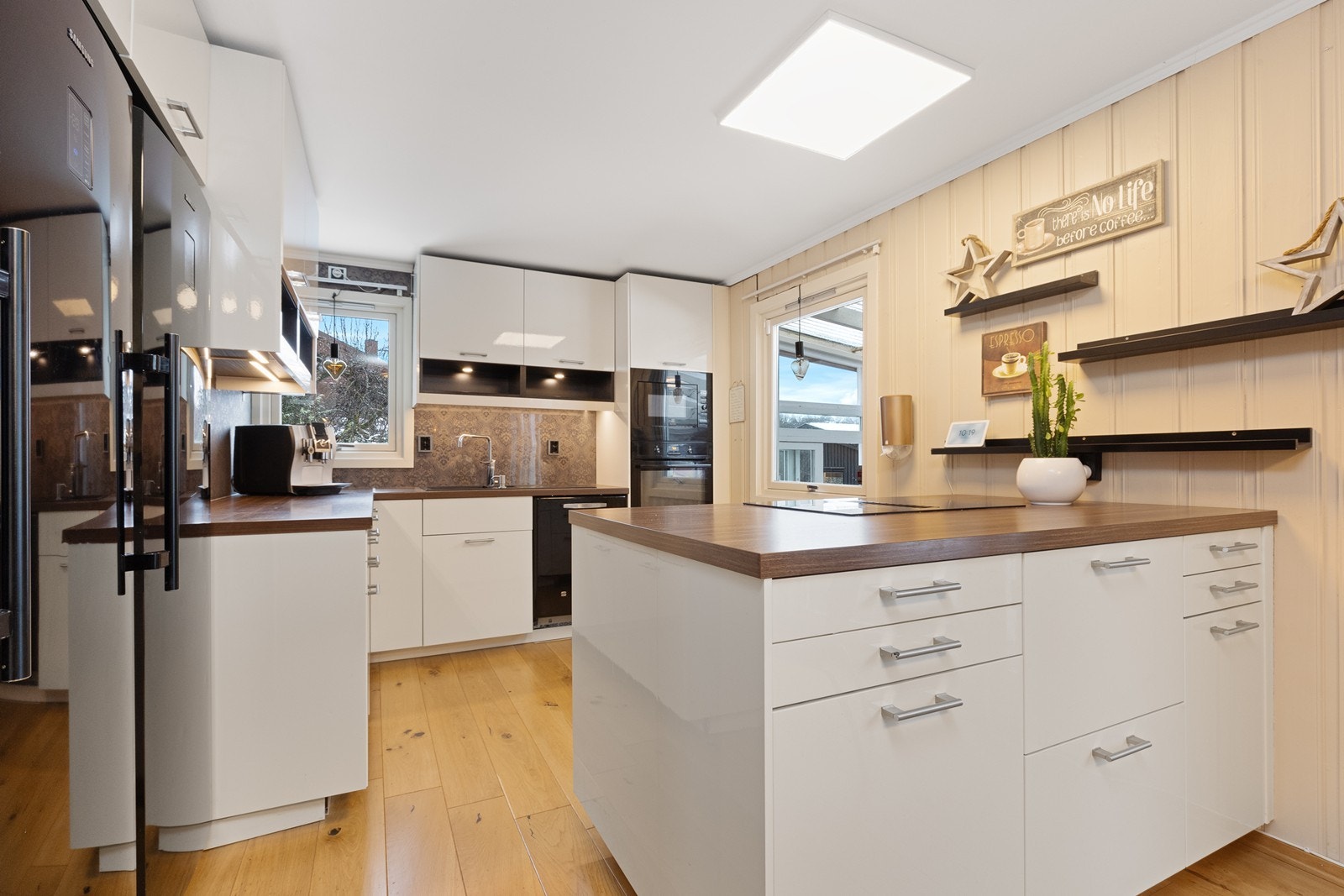 Kjøkkenet fra 2014 har en moderne, hvit innredning med en praktisk kjøkkenøy. Galleribilde