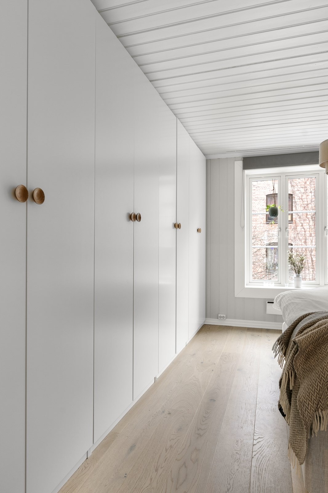 Det er etablert garderobeskap langs hele langveggen i rommet. Her er det rikelig med plass til klær og sko. Galleribilde