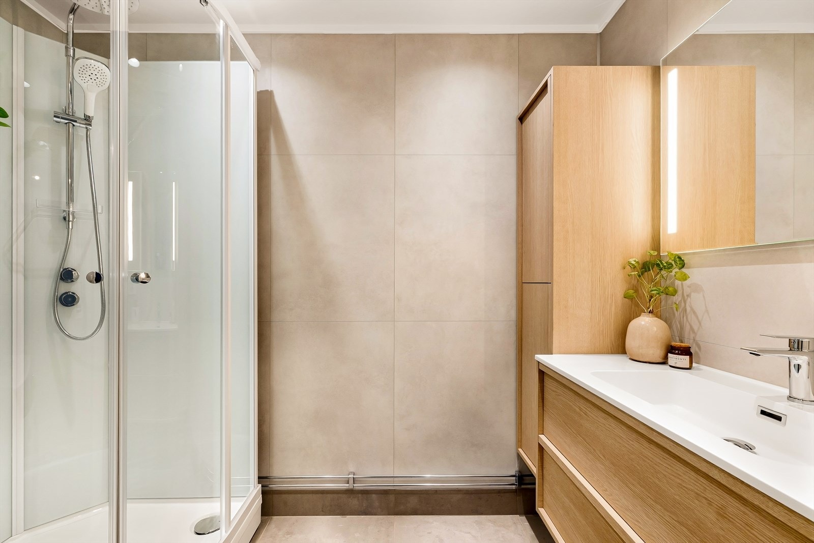 Innredningen består av nedfelt servant, speil med integrert belysning, høyskap, dusjkabinett og opplegg for vaskemaskin. Det er elektrisk styrt vifteHimlingen er senket for integrerte downlights, noe som gir rommet et rent og moderne uttrykk. Galleribilde