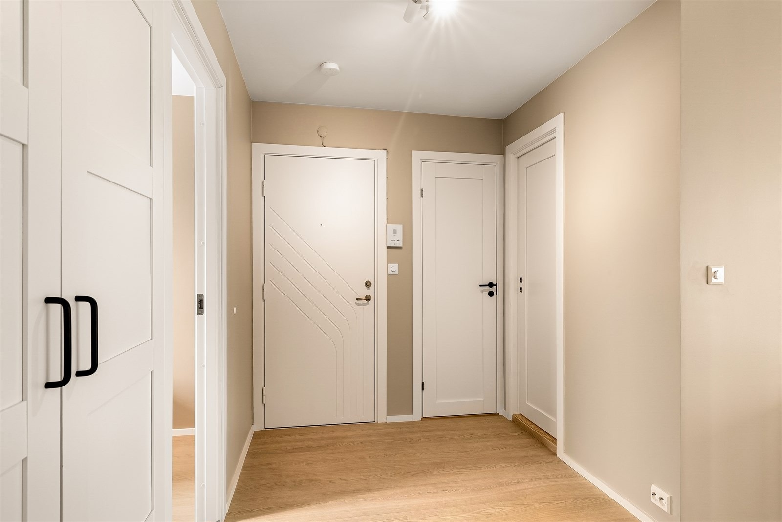 Vel inne ankommer man leilighetens morderne og stilrene entré. Et funksjonelt garderobeskap er montert og sørger for rikelig plass til å henge fra seg yttertøy. Galleribilde