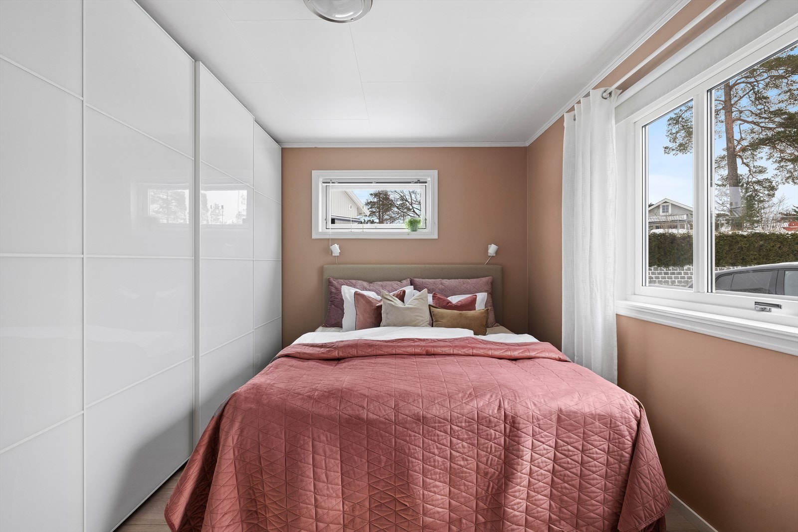 Soverommet i første etasje har en lun terracotta-farge og en stor skyvedørsgarderobe. Galleribilde