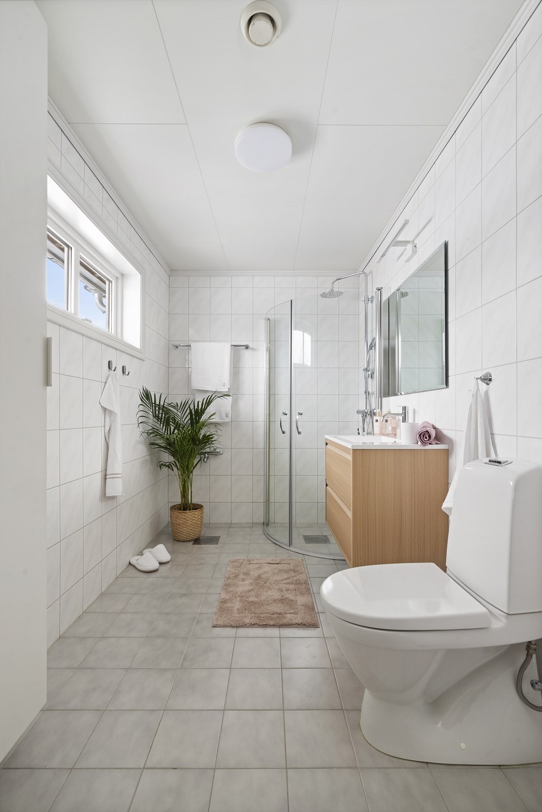 I andre etasje ligger hovedbadet, som er lyst og romslig med hvite fliser, dusjhjørne i glass, toalett og en delikat servantinnredning i treverk. Galleribilde