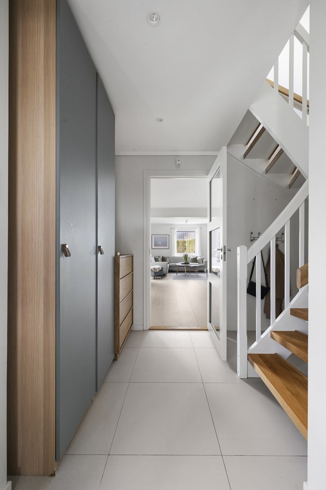 Entréen har store, lyse gulvfliser og moderne downlights i taket. Her er det montert en stilig garderobeløsning som gir rikelig med lagringsplass. Galleribilde