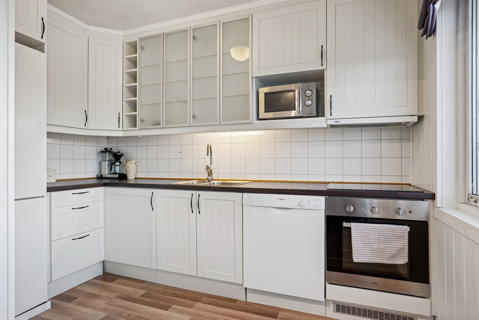 Kjøkkenet har greit med skap og benkeplass Galleribilde