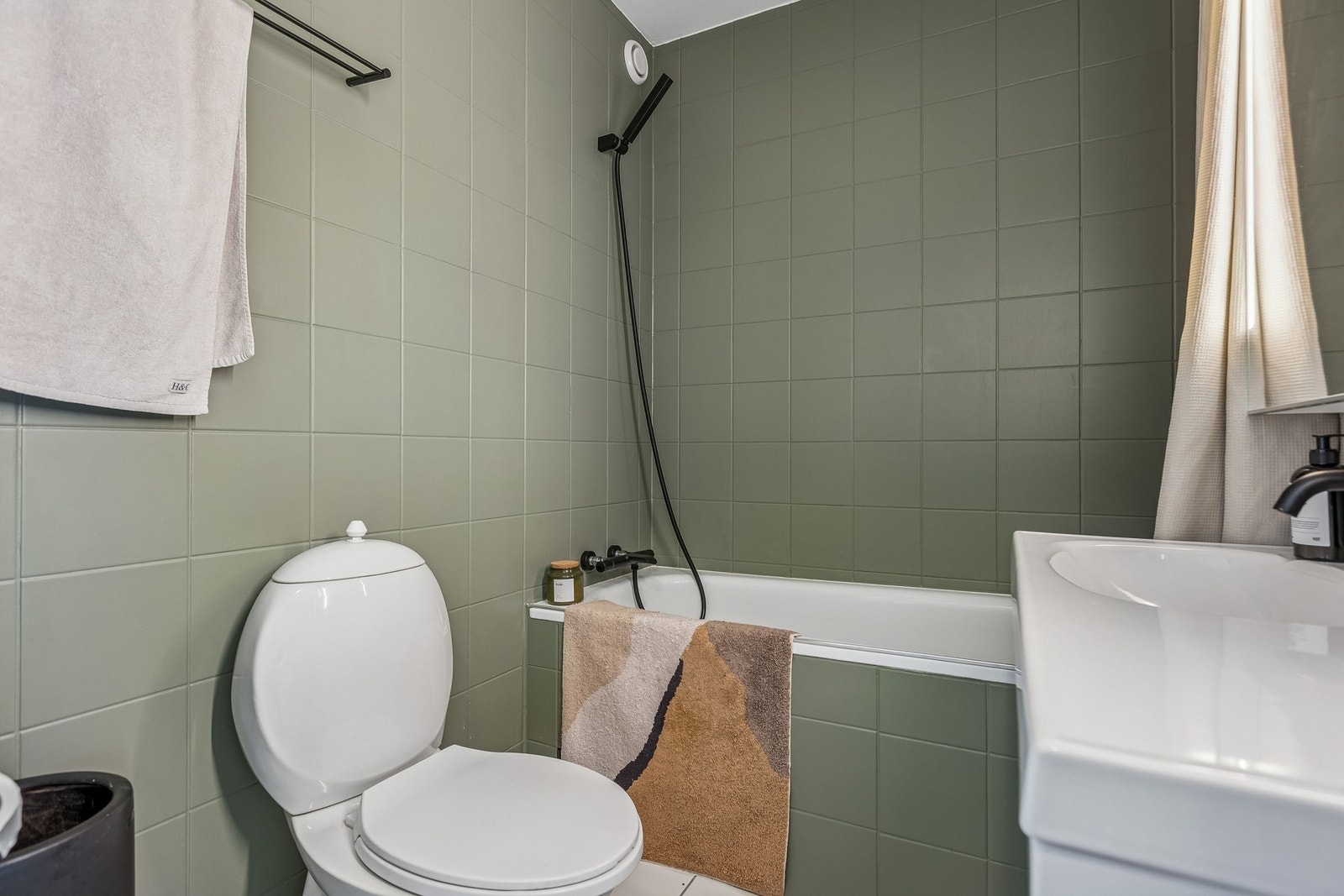 Av utstyr finnes bl.a. helstøpt servantplate, speilskap med integrert belysning, gulvmontert toalett, badekar med dusjforheng samt veggmontert blandebatteri og dusjgarnityr Galleribilde