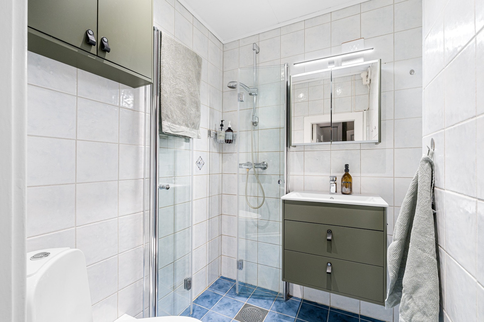 Flislagt bad med dusjhjørne, glassvegger og moderne baderomsinnredning. Badet har elektriske varmekabler. Galleribilde