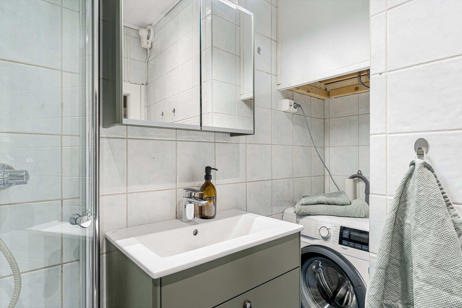 Praktisk bad med gode oppbevaringsmuligheter i innredning og speilskap. Badet har også opplegg for vaskemaskin. Galleribilde